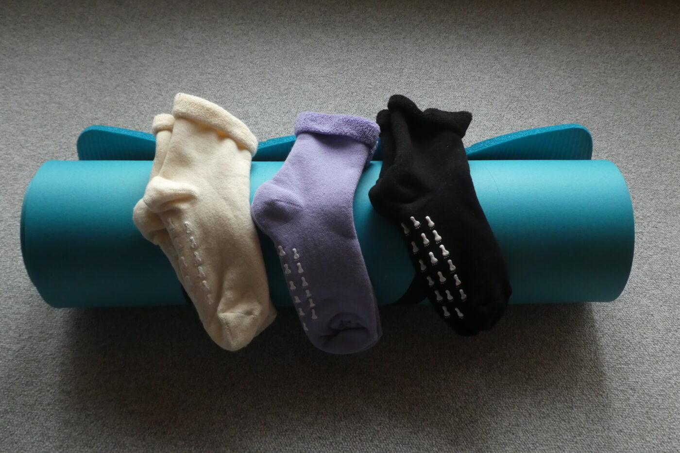 Gerollte Yoga Matte mit 3 Paar Stoppersocken